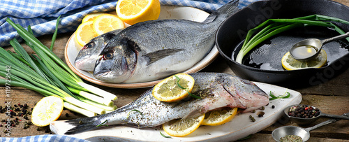 Photography Raw fresh dorado fish on a wooden background.