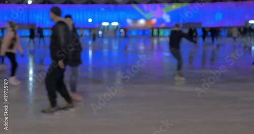 Soft focus clip of ice rink inside Sokolniki Park. People skating in blue light. Moscow, Russia photo