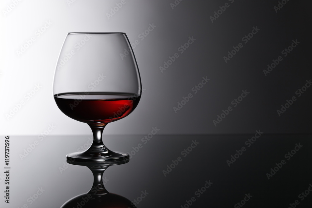 snifter of brandy on glass table snifter of brandy on glass table