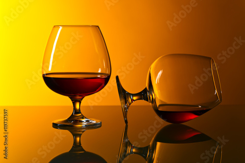 Two snifters of brandy on glass table