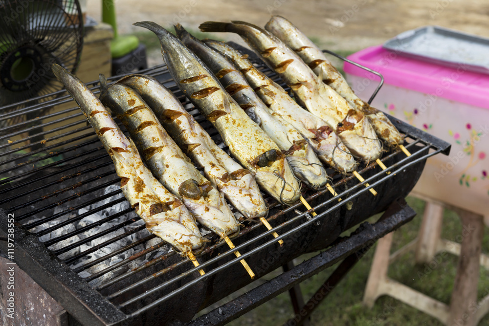 Marinate catfish on the grill at the market in Thailand