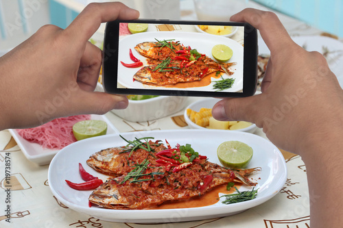 Take photo a dish of mackerel fish fried topped spicy curry with side dish to share for social network.Selective focus.