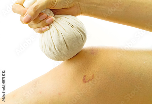 Woman massage with herbal compress balls her knee