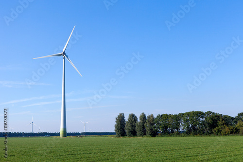 Wind turbine spinning with in a green countryside environment