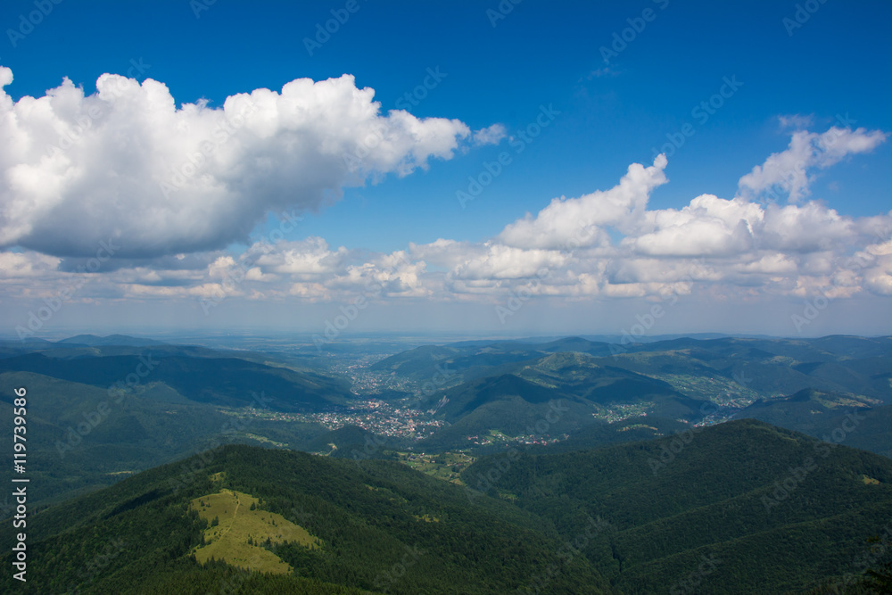 Forest mountains and meadows under clouds