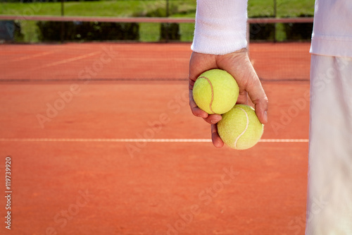 Close up of tennis balls in sportsman hand © luckybusiness