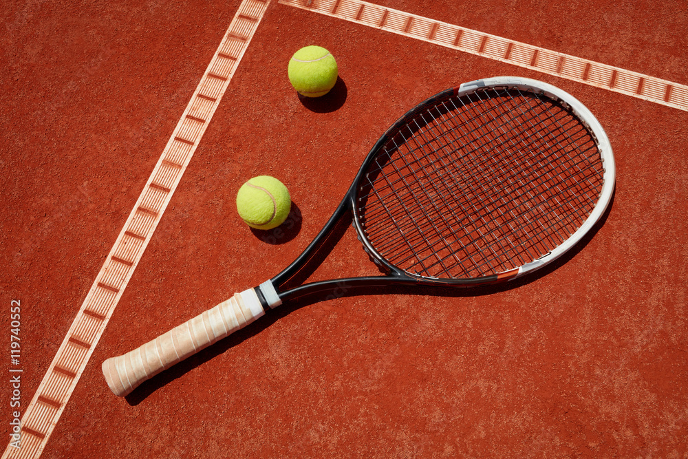 Close up racket and balls on tennis terrain