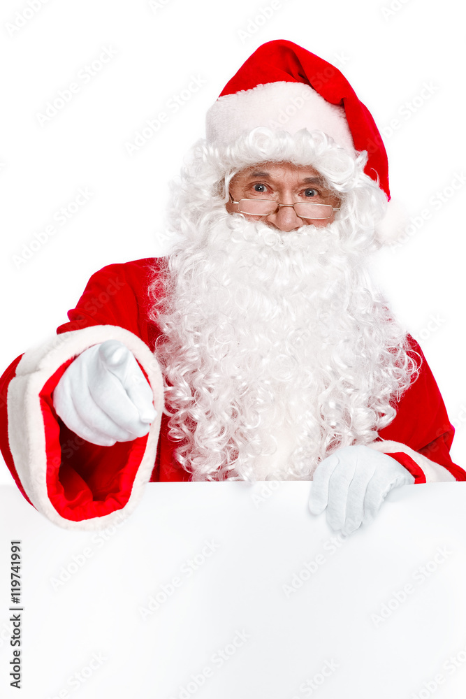 Merry Christmas to you! Traditional Santa Claus pointing you and holding white banner on white background. Copy space
Merry Christmas to you! Traditional Santa Claus pointing you and holding white banner on white background. Copy space