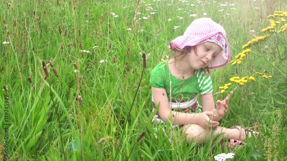 Pensive little girl sitting on the meadow
Pensive little girl sitting on the meadow