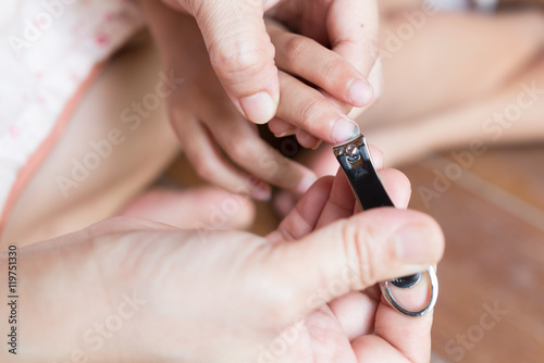  little girl and her mother cutting dirty nails - focus on finge