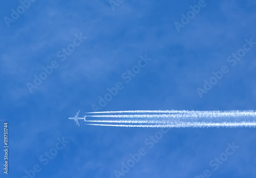 Airplane with contrails in clear blue sky, Cruising altitude © vladimircaribb