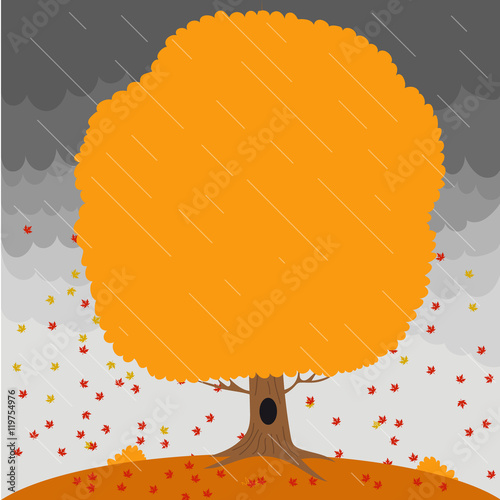 Autumn tree in the rain and falling leaves on the background a stormy sky