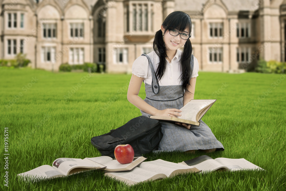 Pretty Chinese student reads books at park Pretty Chinese student reads books at park