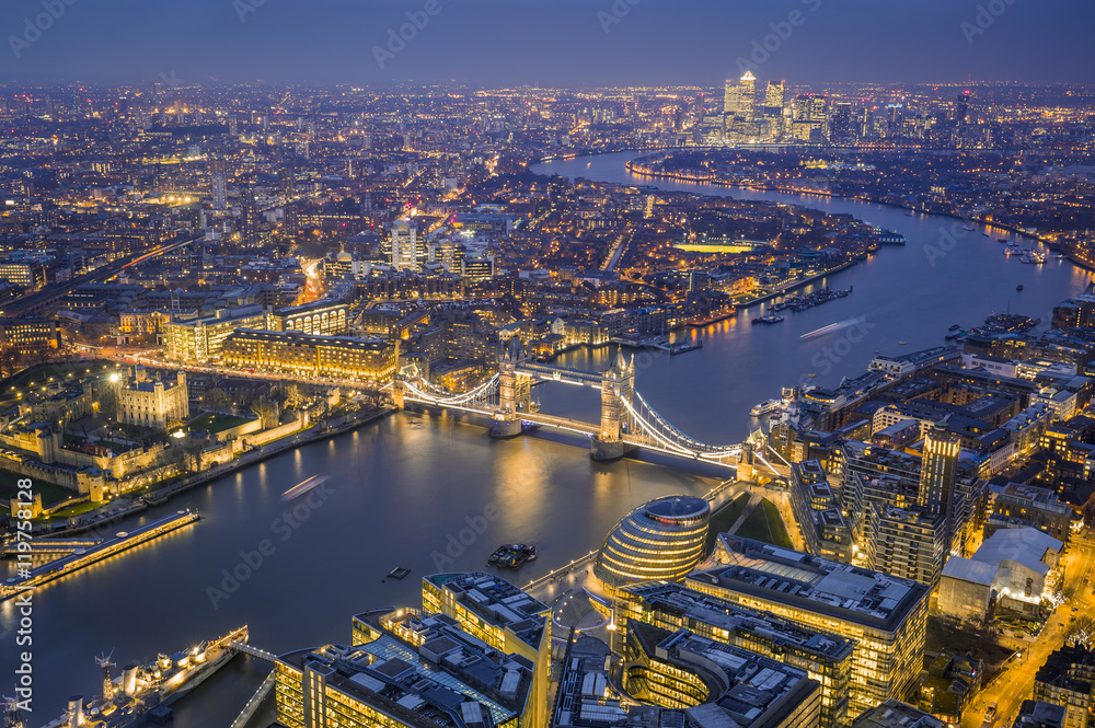 London, England - Aerial Skyline view of London. This view includes the Tower of London, the iconic Tower Bridge, HMS Belfast ship and skyscrapers of Canary Wharf at blue hour