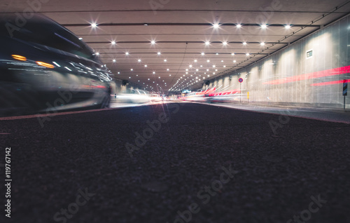 Fast cars in a modern tunnel by night