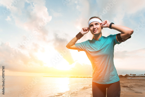 Young sporty girl doing morning exercises on beach at sunrise © bodiaphoto