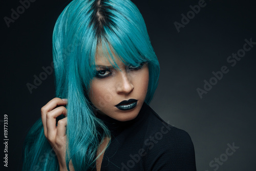 Portrait of a young woman with a cyan color hair