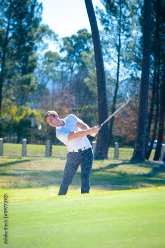 golfer playing a chip shot onto the green