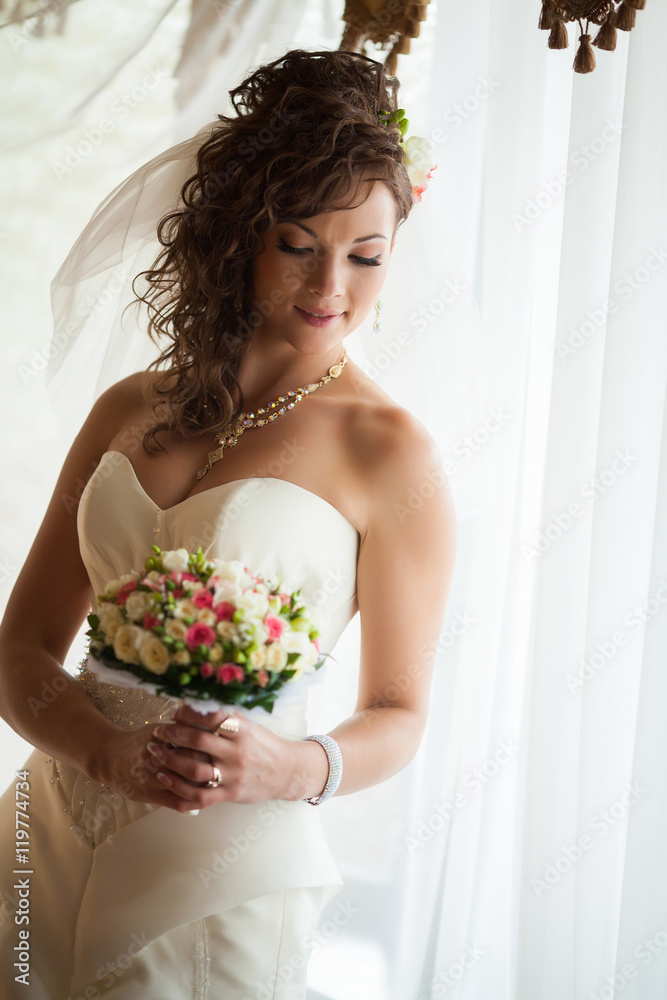 Beautiful young bride with wedding makeup and hairstyle in bedroom, newlywed woman final preparation for wedding. Happy Bride waiting groom. Marriage Wedding day moment. Bride portrait soft focus Beautiful young bride with wedding makeup and hairstyle in bedroom, newlywed woman final preparation for wedding. Happy Bride waiting groom. Marriage Wedding day moment. Bride portrait soft focus