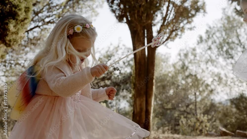 Two children in fairy costumes twirling in trees Two children in fairy costumes twirling in trees