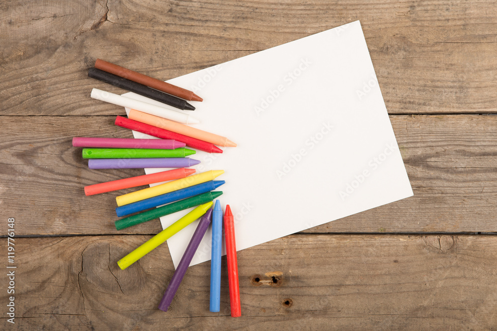 Obraz premium colored crayons and blank page on the wooden table