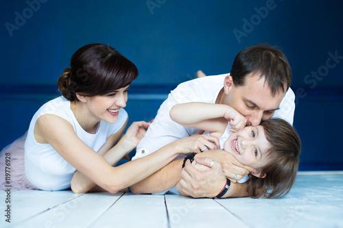 Happy portrait of a laughing young family sitting on the floor w