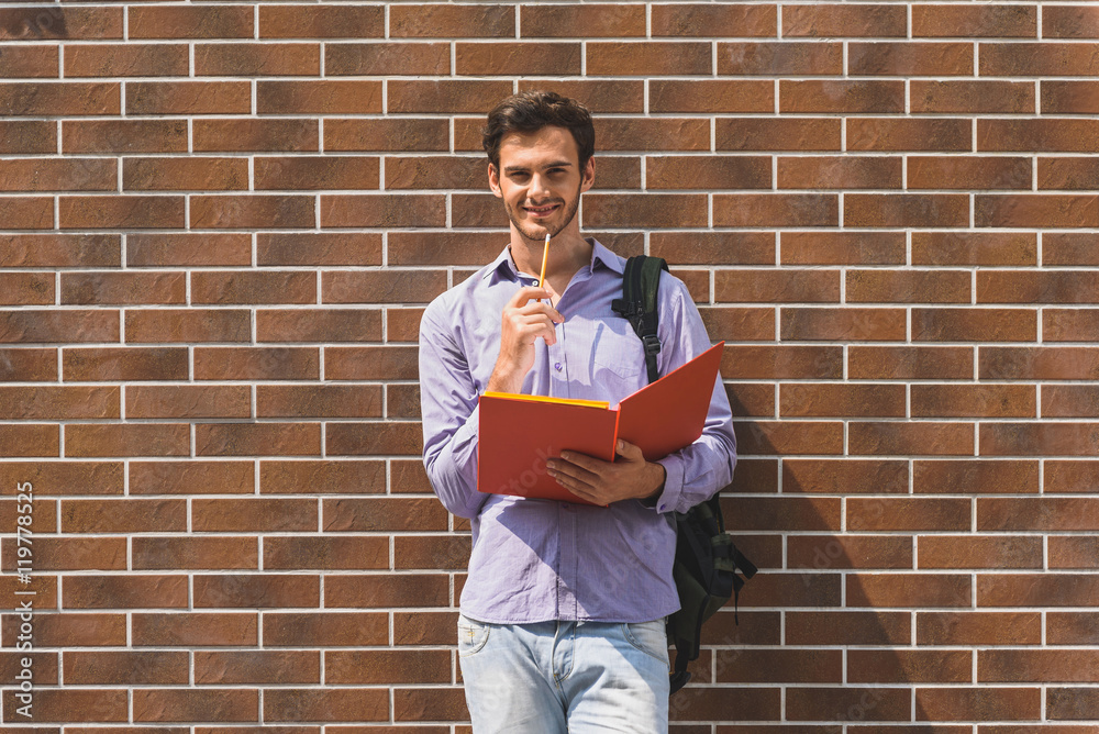 Carefree young guy studying with joy Carefree young guy studying with joy