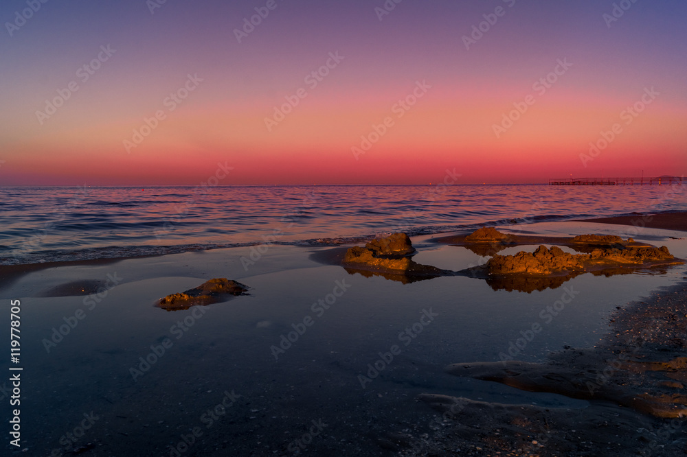 Spiaggia, mare con cielo rosso al tramotno. Sea, beach at sunset with red sky