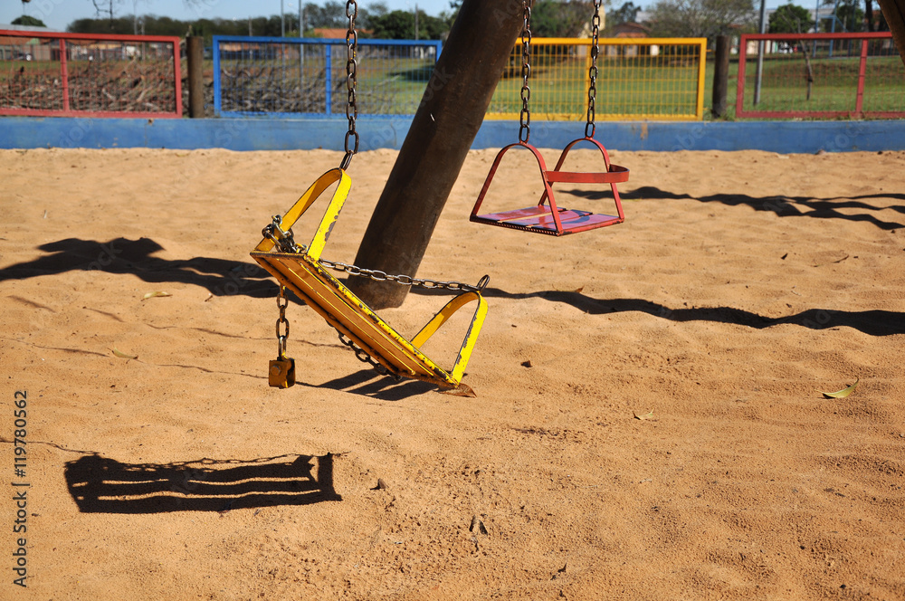 Fototapeta premium Broken children swing in the park with sand