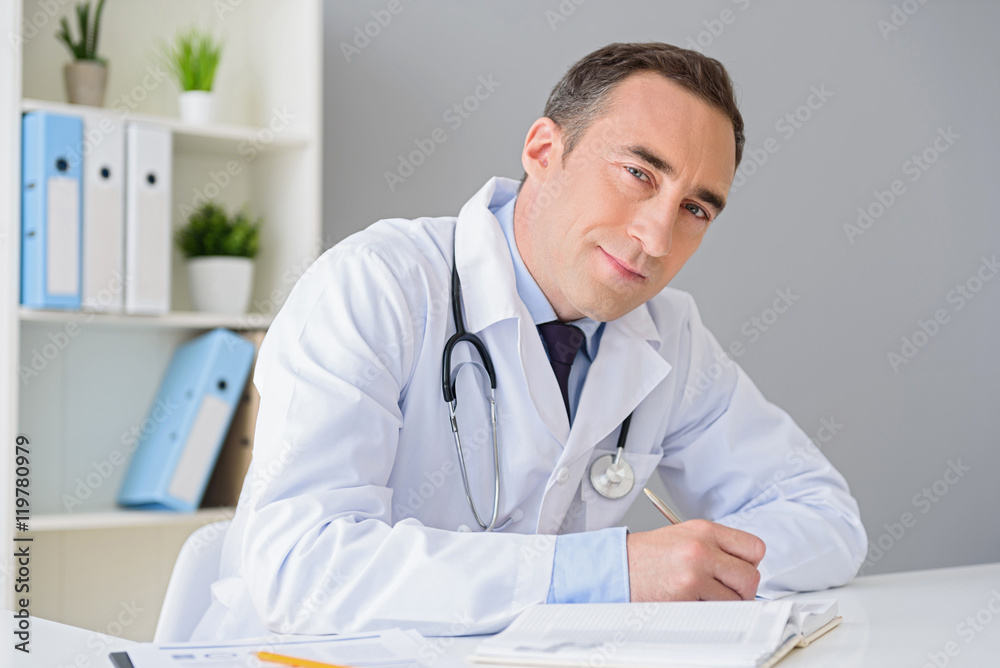 Portrait of adult doctor sitting at his desk Portrait of adult doctor sitting at his desk