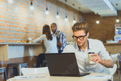 Busy man using computer in cafeteria