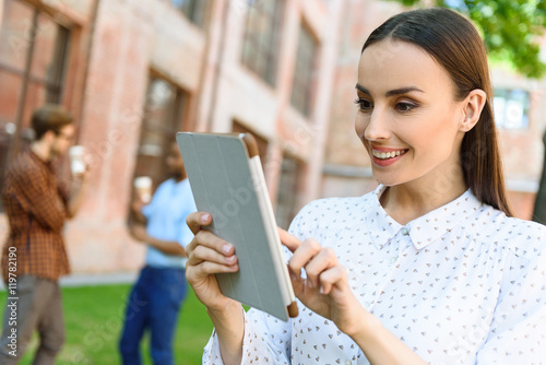 Cheerful businesswoman resting with modern gadget