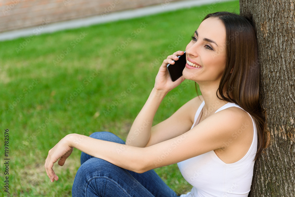 Fototapeta premium Cheerful woman talking on mobile phone