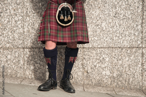 bagpiper dressed in kilt playing bag pipes