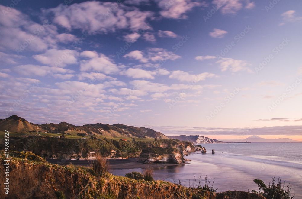 Fototapeta premium sunset over sea shore rocks and mount Taranaki, New Zealand