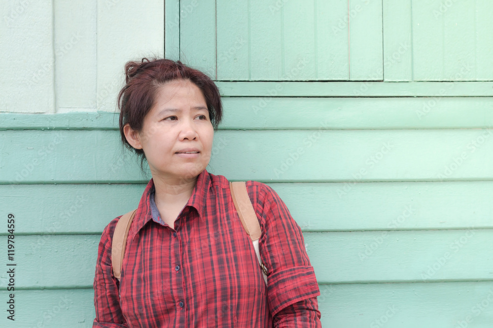 Asian woman standing on wooden floor waiting for someone in fro Asian woman standing on wooden floor waiting for someone in fro