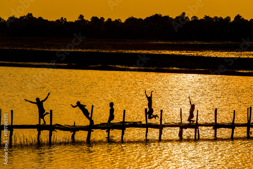 Rural lifestyle of children in Thailand / Children on wooden old bridge are jumping into the river in rural of Thailand