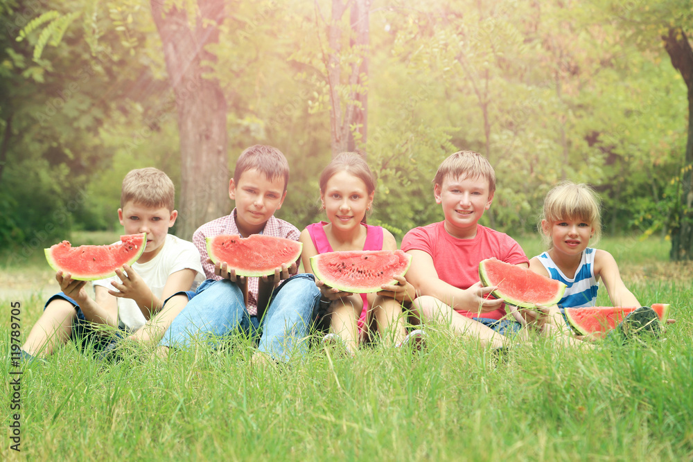 Obraz premium Children in the park with slices of watermelon