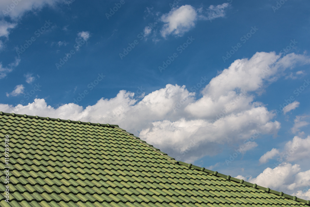 green tile roof on a new house with blue sky green tile roof on a new house with blue sky
