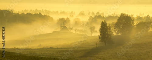 Piękny,mglisty wschód słońca nad wiejską łąką
