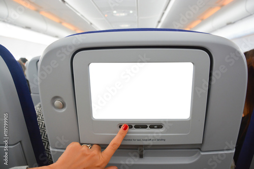 Woman hand pressing display or touchscreen inside aircraft