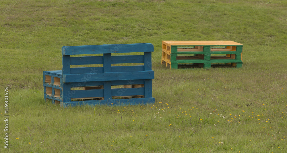 Colorful furniture made of pallet stands on the grass. Chair, table. Colorful furniture made of pallet stands on the grass. Chair, table.