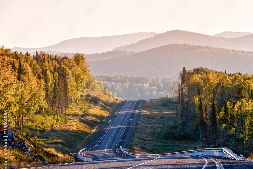Road in the autumn on a background of mountains
