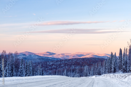 The road in the winter mountains in the background 