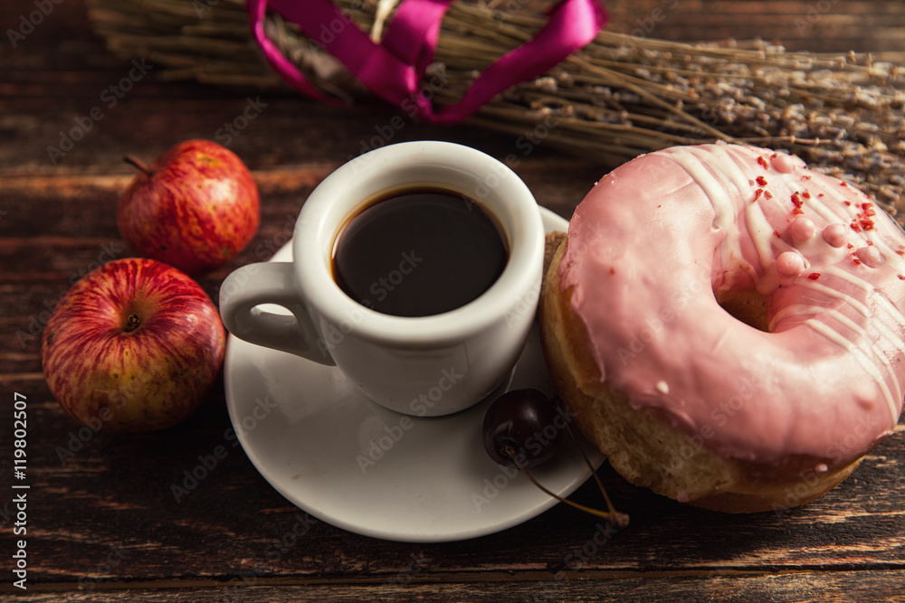 fresh donut with coffee on wooden table with napkin, spoon and c