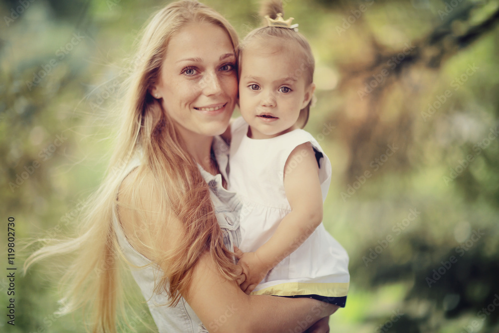 Mom holding daughter in her arms autumn photos in yellow park Mom holding daughter in her arms autumn photos in yellow park