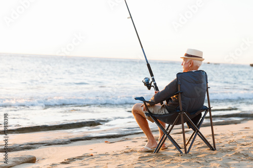 Senior man fishing at sea side