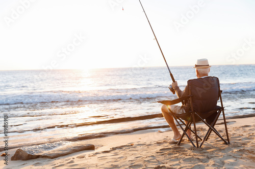 Senior man fishing at sea side photo