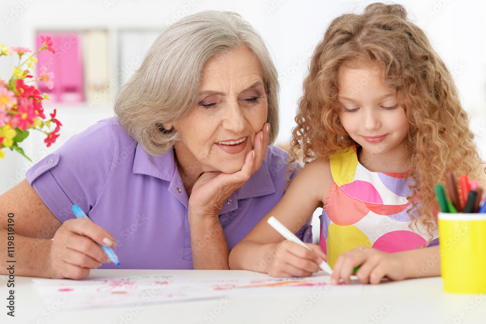 Grandmother with her cute granddaughter drawing Grandmother with her cute granddaughter drawing