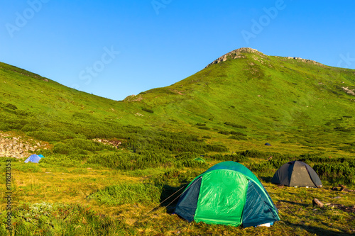 Camping tent in Carpathian mountains, sunrise morning time, summertime journey.